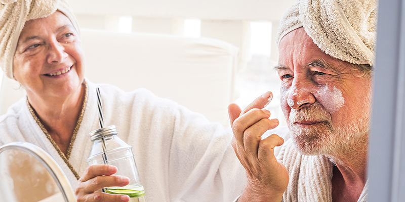 Senioren Paar in Bademänteln bei der Hautpflege