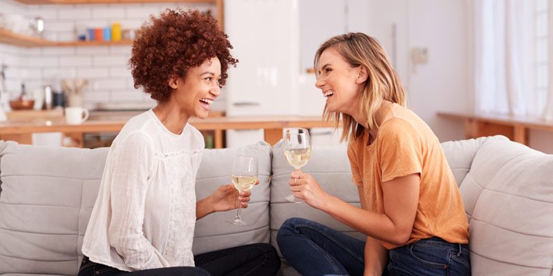 Zwei Frauen unterhalten sich bei einem Glas Wein