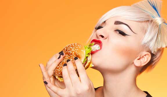Junge Frau isst einen Burger