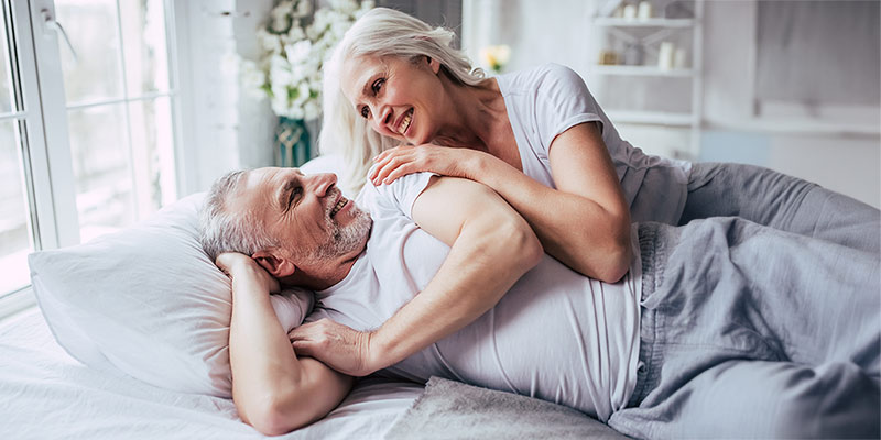 Glückliches Paar liegt entspannt im Bett