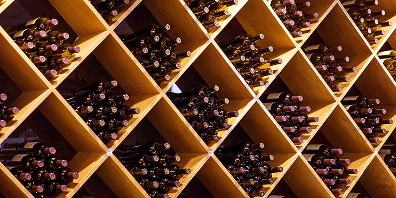 In einem Weinregal werden mehrere Weinflaschen gelagert