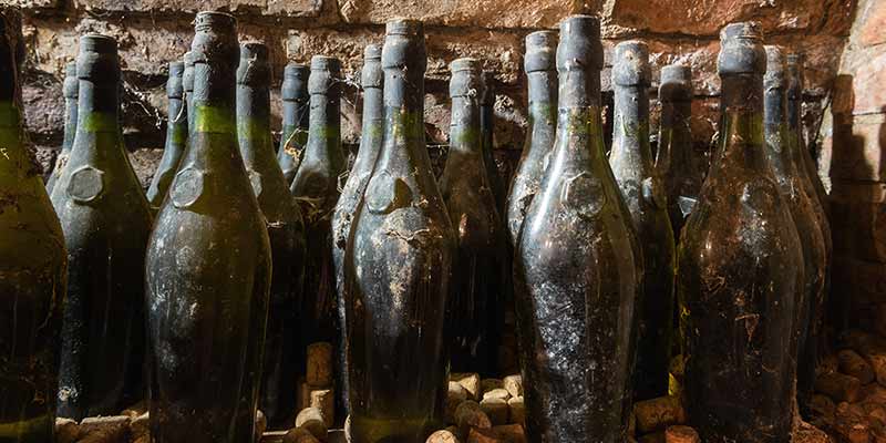 Verschmutzte Weinflaschen in einem Weinkeller