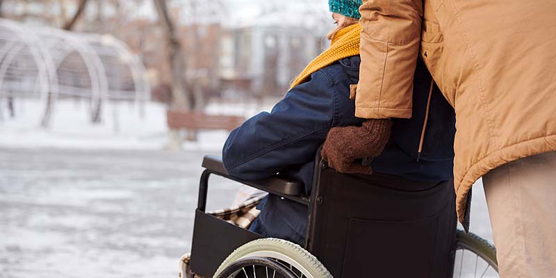 Rückenansicht von Rollstuhlfahrerin im Winter