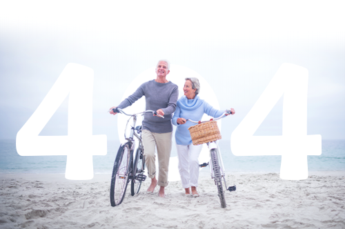 Älteres Paar mit Fahrrad am Strand