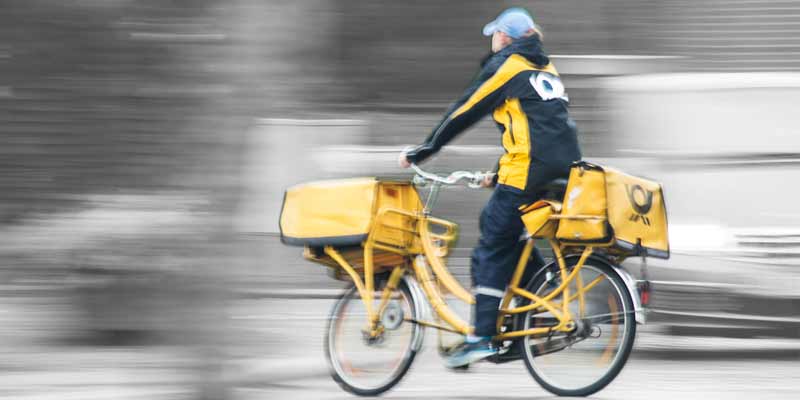 Postbote liefert Briefe mit einem Fahrrad aus