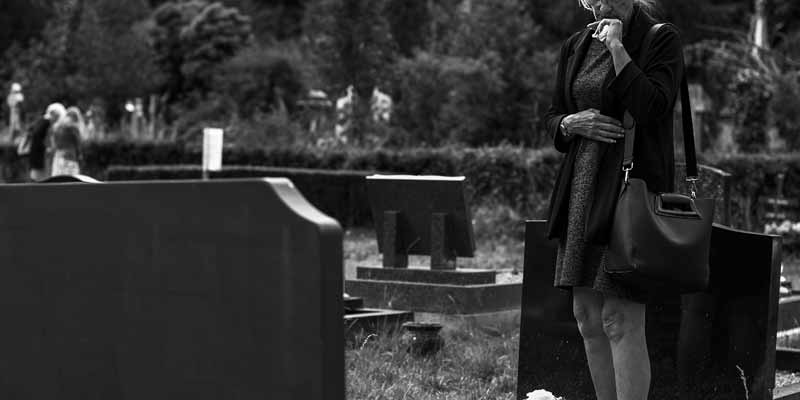 Frau trauert auf Friedhof